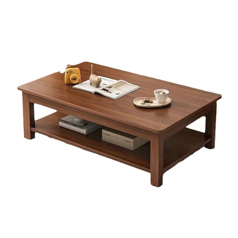 A rectangular wooden coffee table with a dark brown finish, featuring two open shelves and styled with a yellow camera, an open book, and a cup on a saucer against a plain white background.