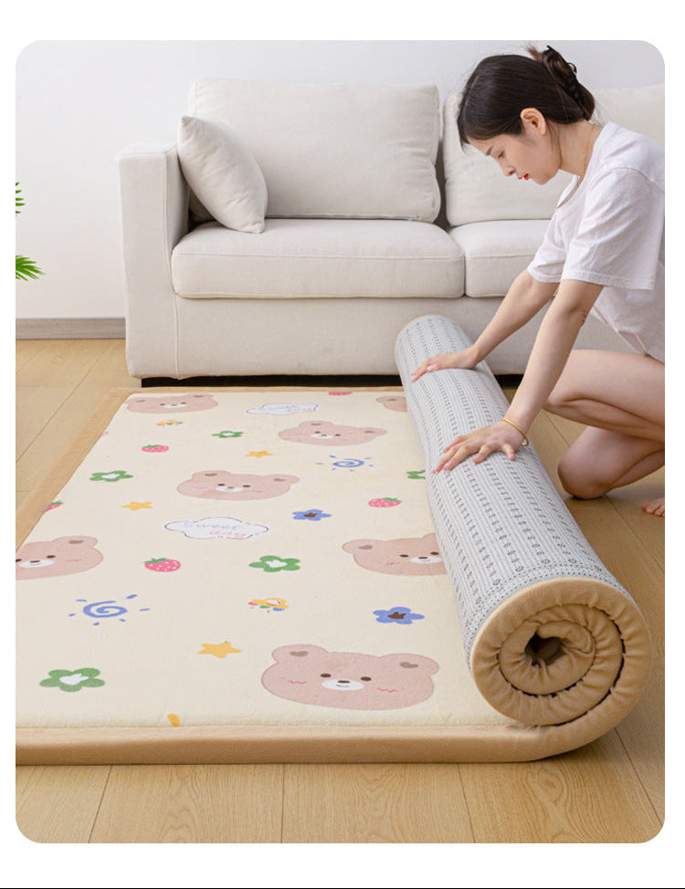 A woman unrolls a beige floor mat with a cartoon bear pattern in a bright living room. The mat is shown partially rolled, with a light gray textured underside visible.