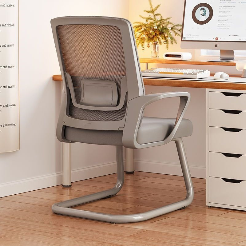 A modern gray ergonomic office chair with a mesh back and cantilever base, positioned in front of a wooden desk in a bright home office setting.