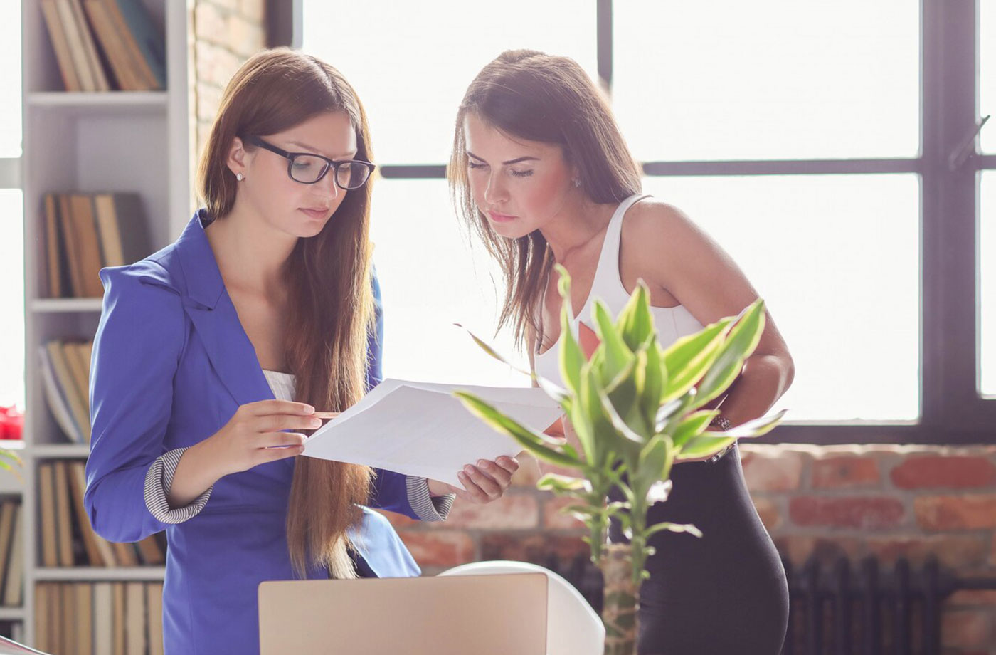 two girls looking at a document